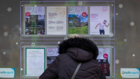 Woman looks in estate agent's window