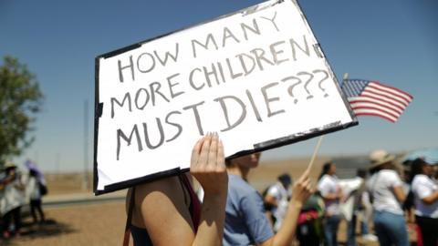 Proteste ith a sign asking 'how many more children must die' outside Texas border control facility