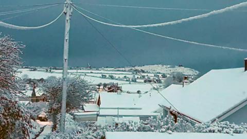 Snow on rooftops and across fields