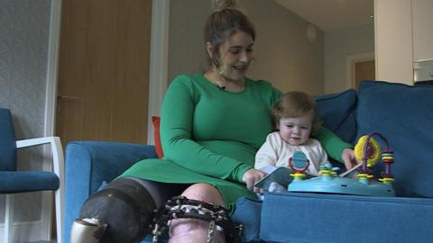 Digital therapy patient Ruby Flanagan sits on a sofa in her home with son Leon