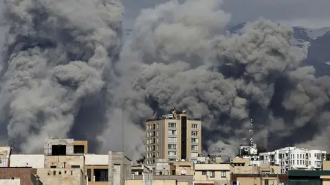  Plumes of smoke rise following reported explosions in Tehran on March 1, 2026