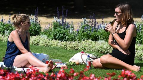 Women sitting in the sunshine in Hyde Park, London