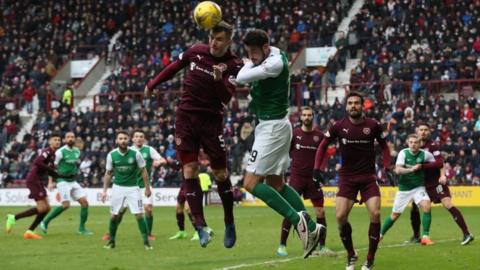 Players heading a ball during Hibs vs Hearts match