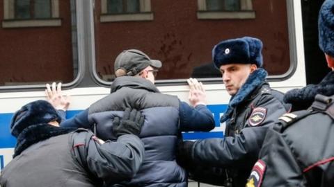 Russian police search an opposition activist during a protest rally in central Moscow in support of Vyacheslav Maltsev's Artillery preparation movement