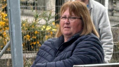 Yvonne Keenan pictured outside court. She has shoulder-length brown hair and is wearing glasses and a blue puffa jacket