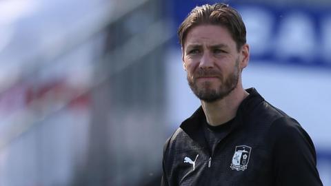 Sam Foley looks on wearing a black tracksuit top