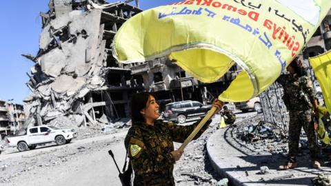 Commander Rojda Felat waves a Syrian Democratic Forces flag in Raqqa on 17 October 2017