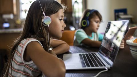 Two children on laptops