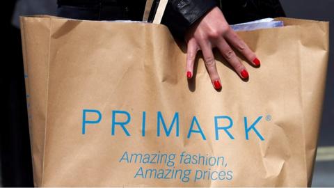 File photo showing a shopper carrying a bag from clothing retailer Primark in London (2013)