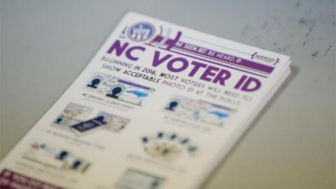 ]A pile of government pamphlets explaining North Carolina"s controversial "Voter ID" law sits on table at a polling station in Charlotte, North Carolina