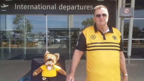 Mick Chance at airport with mascot Wolfie