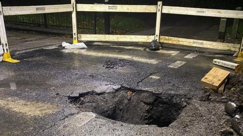 Hole in road caused by burst water main