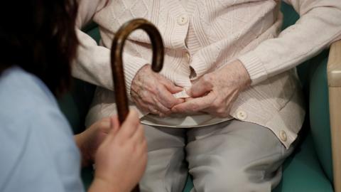 Healthcare worker with elderly woman in care home