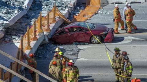 Emergency personnel works on a collapsed pedestrian bridge on the Florida International University in Miami, Florida.