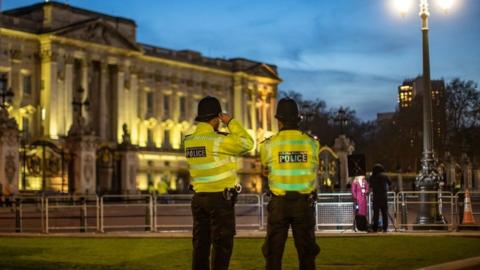 Police stand at Buckingham Palace