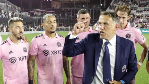 Coach Phil Neville speaks to his Inter Miami players on the pitch after a game in March 2023