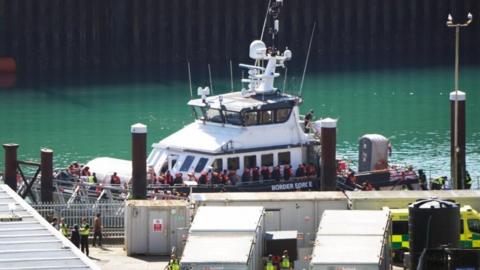 a Border Force boat with a crowd of people wearing life jackets