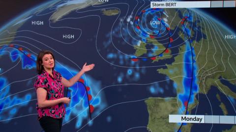 Gillian Smart wears a pink shirt with black and turquoise pattern. She presents the weather in front of a green screen which shows low pressure over Scotland.