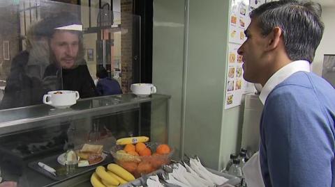 Rishi Sunak talks to a homeless man at a shelter in London