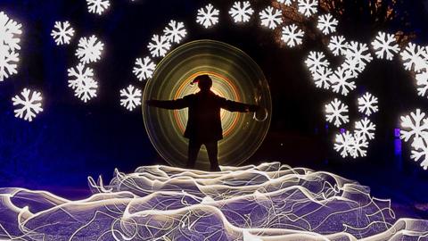 Light painter Kevin Jay stands in a Christmas scene