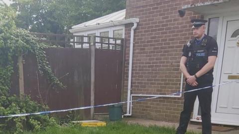 A police officer outside a house in Harlow, Essex