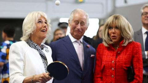 Britain's Queen Camilla plays table tennis next to Britain's King Charles, Brigitte Macron, wife of French President Emmanuel Macron as they meet local youth sports associations in Saint-Denis near Paris, on the second day of their State visit to France, September 21, 2023.