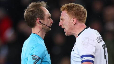 MK Dons captain Dean Lewington argues with referee after being sent off