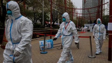 Infection control workers in protective suits