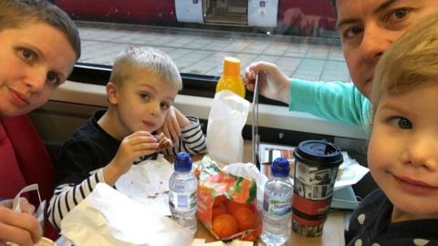 Wilson family sitting at a table on a train