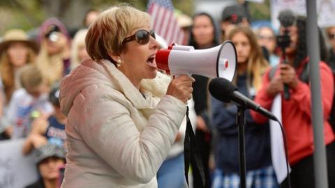 Woman with megaphone at school mask debate