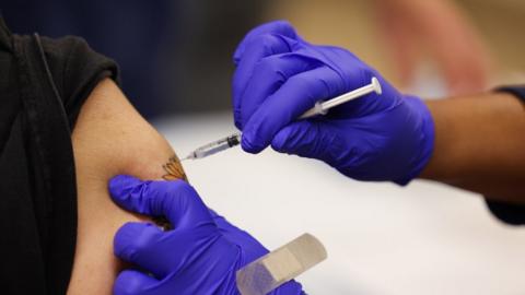 Close-up shot of a Pfizer COVID-19 vaccine booster shot being administered in person's arm