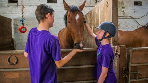 Young people meeting some of Stable Life's horses
