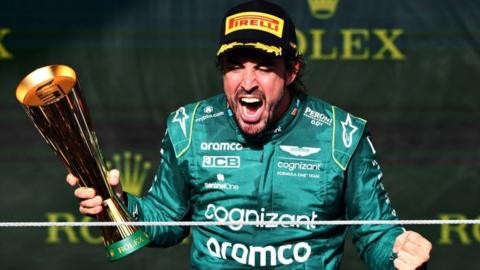 Fernando Alonso celebrating on the podium after securing third place at the Sao Paulo Grand Prix.
