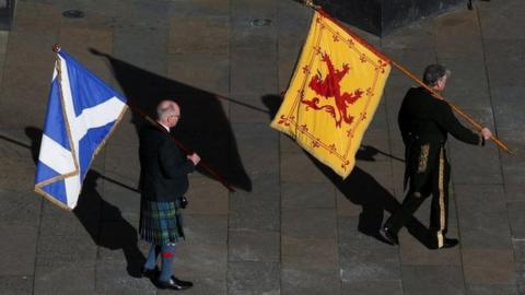 A Lion Rampant and a Saltire are carried into St Giles' Cathedral in Edinburgh ahead of the thanksgiving service for Queen Elizabeth