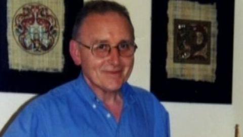 Denis Donaldson wearing glasses and a blue shirt