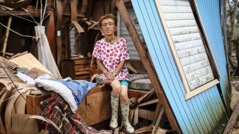 Sonia Torres poses in her destroyed home, three weeks after Hurricane Maria hit, on 11 October 2017 in Aibonito, Puerto Rico