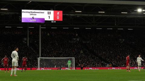 The players wait for VAR to check an offside decision on a goal scored by Liverpool's Florian Wirtz