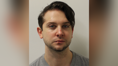 Custody image of Ross Davidson. He has short brown hair and a lip ring