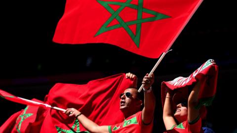 A Morocco fan with a flag at the World Cup