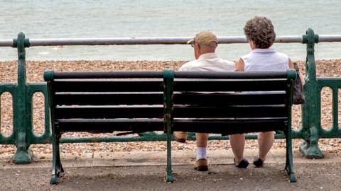 Couple sitting on a bench on the beachfront
