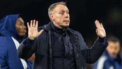 Steve Cooper holds his hands in apology in front of the Nottingham Forest fans after his side's Premier League defeat to Fulham at Craven Cottage