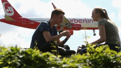 A couple watch as an Air Berlin plane lands at Tegel Airport