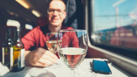 Man drinking wine on a train
