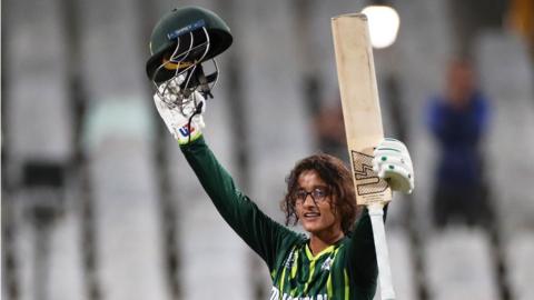 Muneeba Ali raising her bat after hitting a century