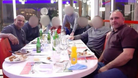 Phillip Ali and Stephen Brown at the dinner table with other people whose faces have been blurred
