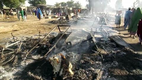 Smouldering ashes and charred items on the ground in Budu, near Maiduguri, after the attack by Boko Haram fighterss on 28 July 2019