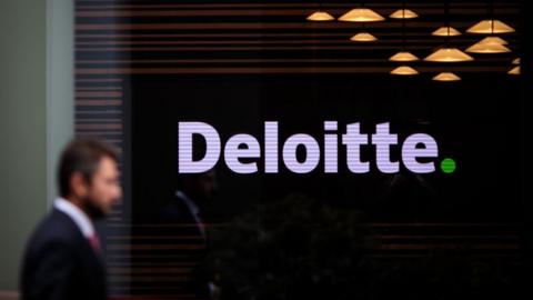 Man walking by a Deloitte office