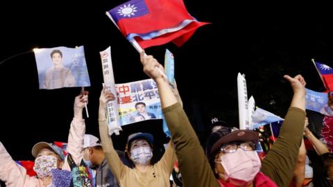 Supporters of the opposition party Kuomintang (KMT) celebrate the preliminary results of the local elections