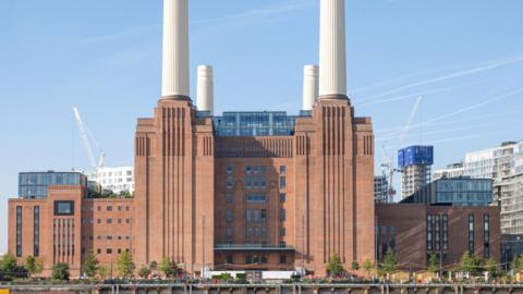 Battersea Power Station - a red brick building with four tall white chimneys