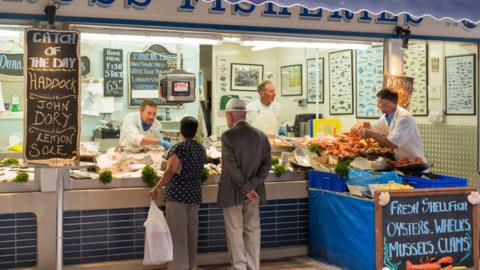 Customers at a fish stall in St Helier, Jersey